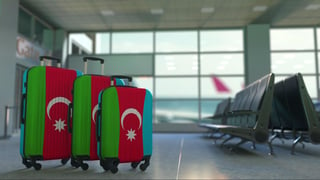 Travel suitcases with flag of Azerbaijan. Azerbaijani tourism conceptual 3D rendering